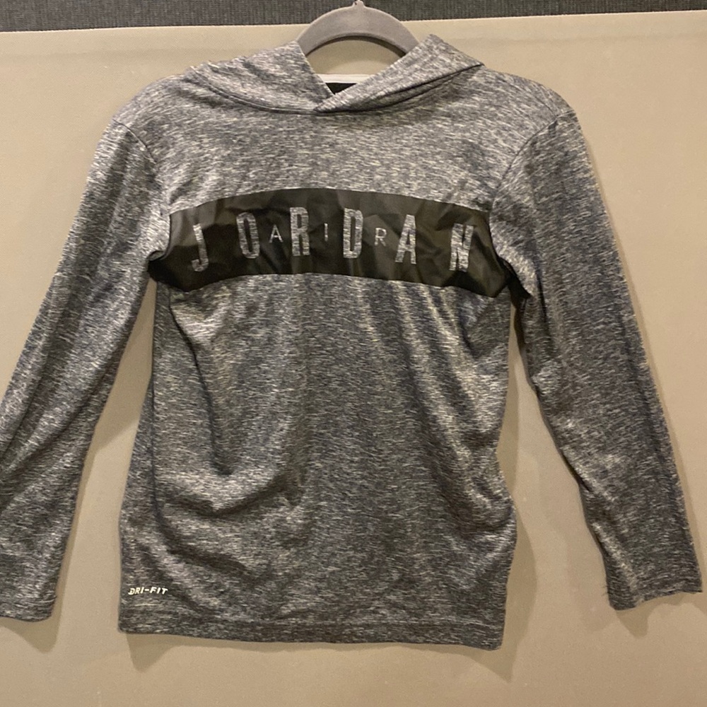 Gray long sleeve shirt with a hoodie and in says Jordan